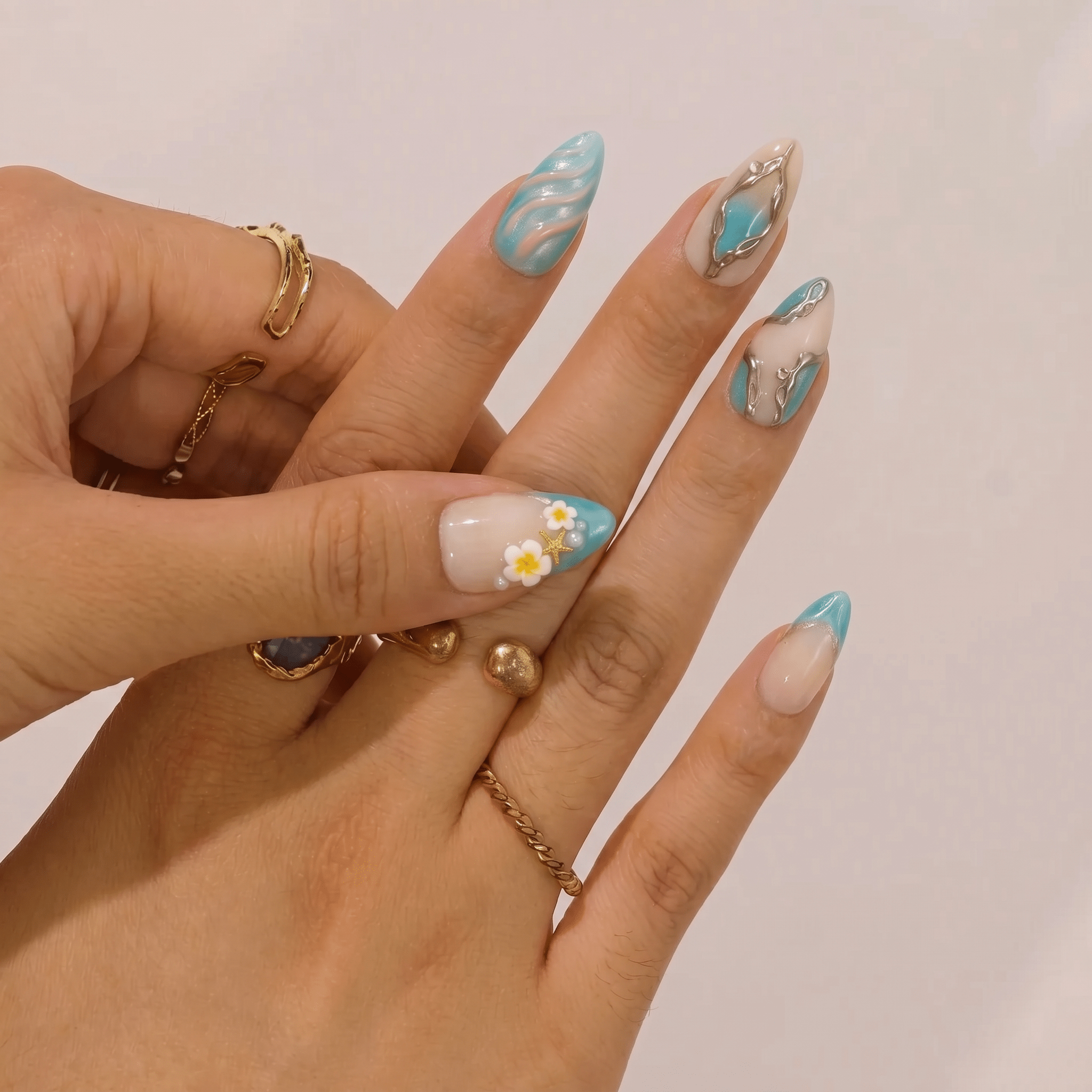 Azure Wavelet press-on nails worn on hand – almond shape by Handora