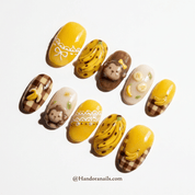 Banana Monkey press-on nails worn on hand – almond shape by Handora