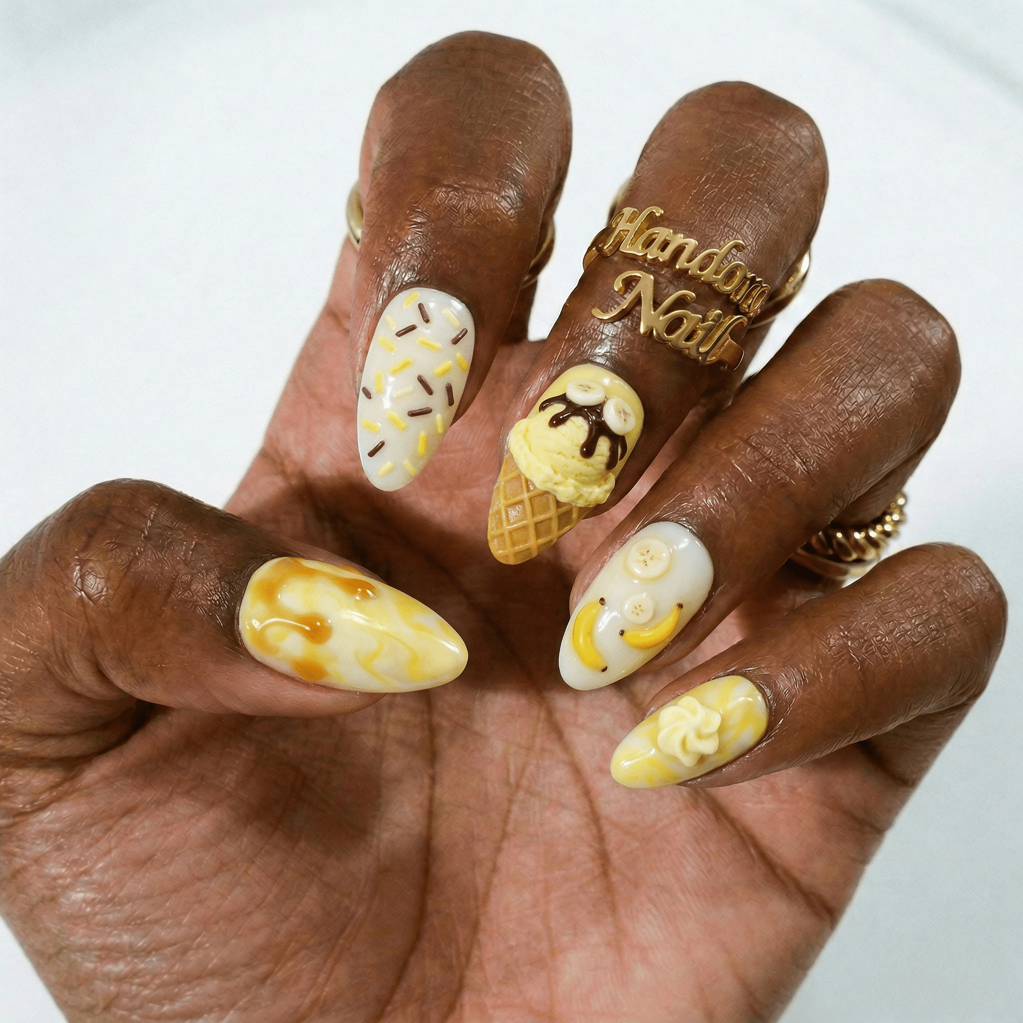 Banana Sundae press-on nails worn on hand – almond shape by Handora
