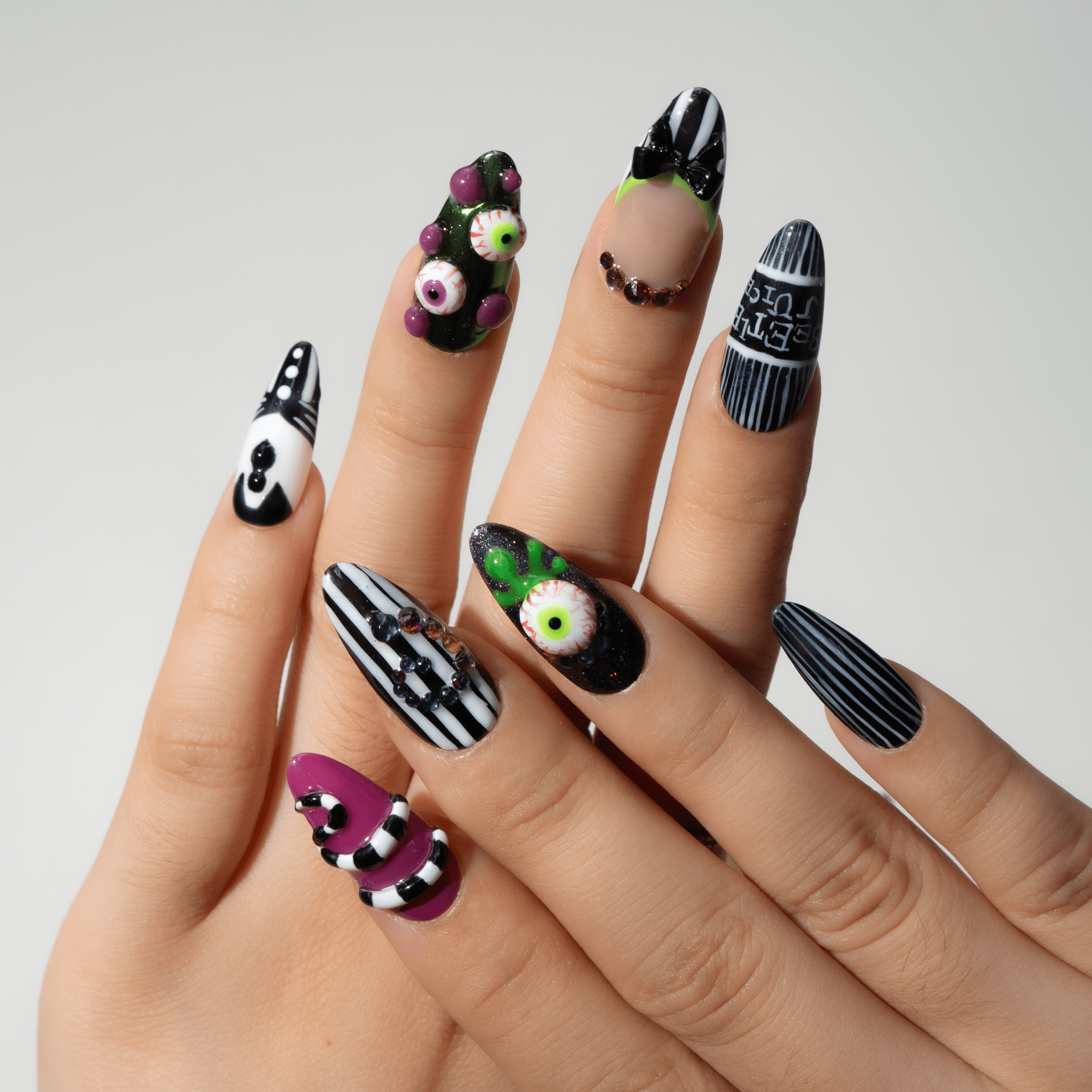 Beetle Glitz press-on nails worn on hand – almond shape by Handora