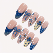 Berry Bows press-on nails worn on hand – almond shape by Handora