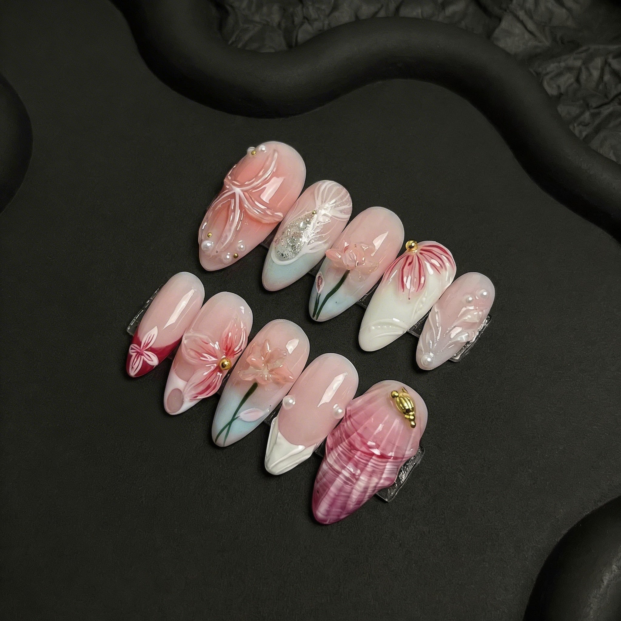 Blush Blossom press-on nails worn on hand – almond shape by Handora
