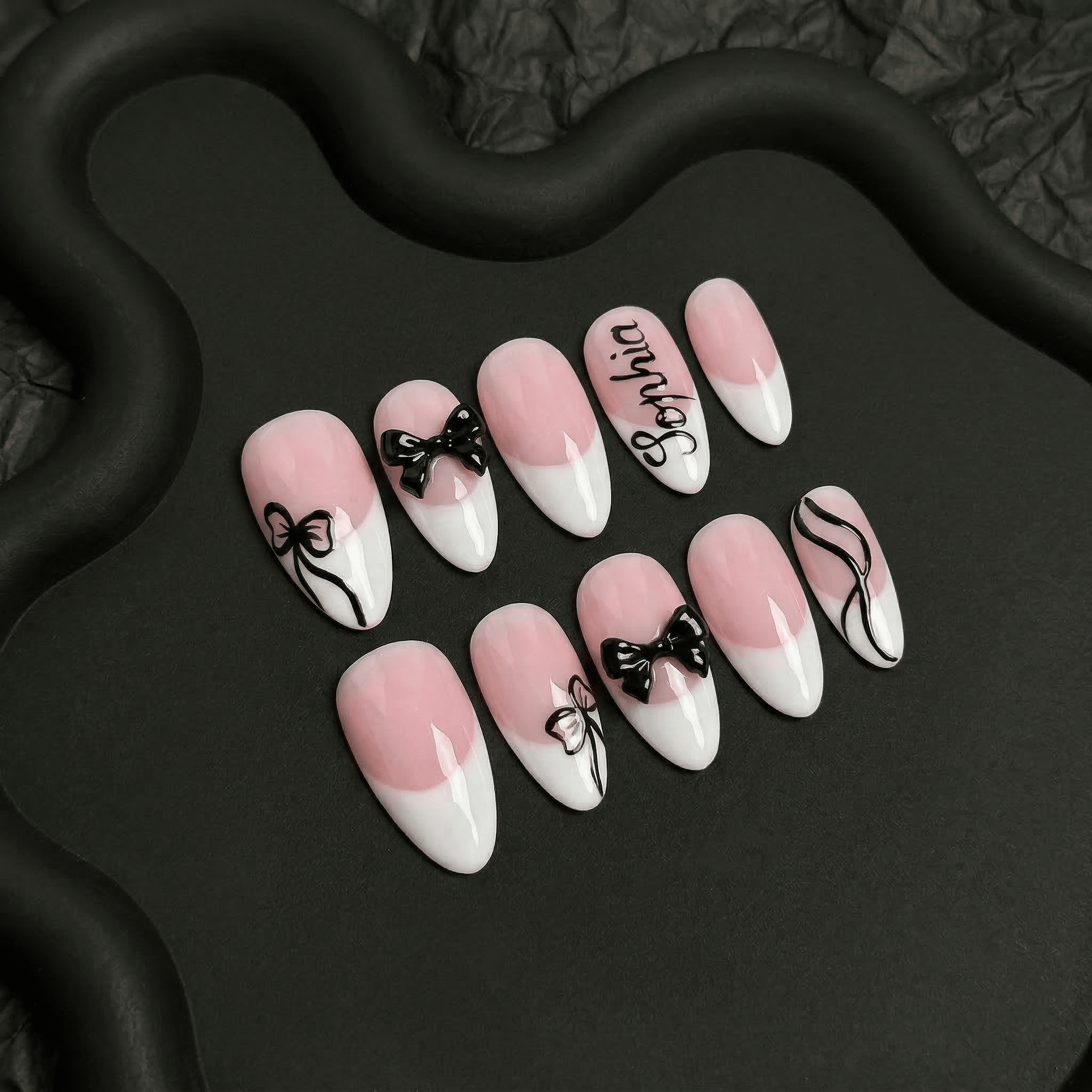 Blush Ribbon press-on nails worn on hand – almond shape by Handora