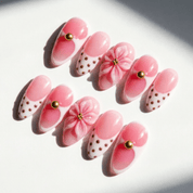Blushing Flora press-on nails worn on hand – almond shape by Handora