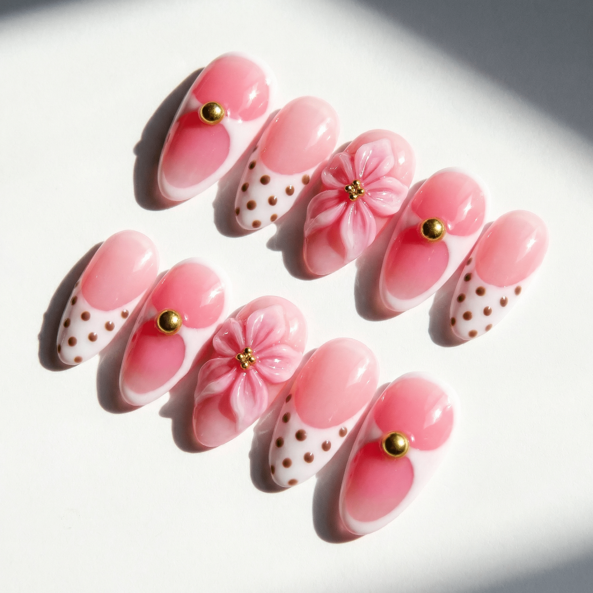 Blushing Flora press-on nails worn on hand – almond shape by Handora