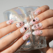 Bow Heart press-on nails worn on hand – almond shape by Handora