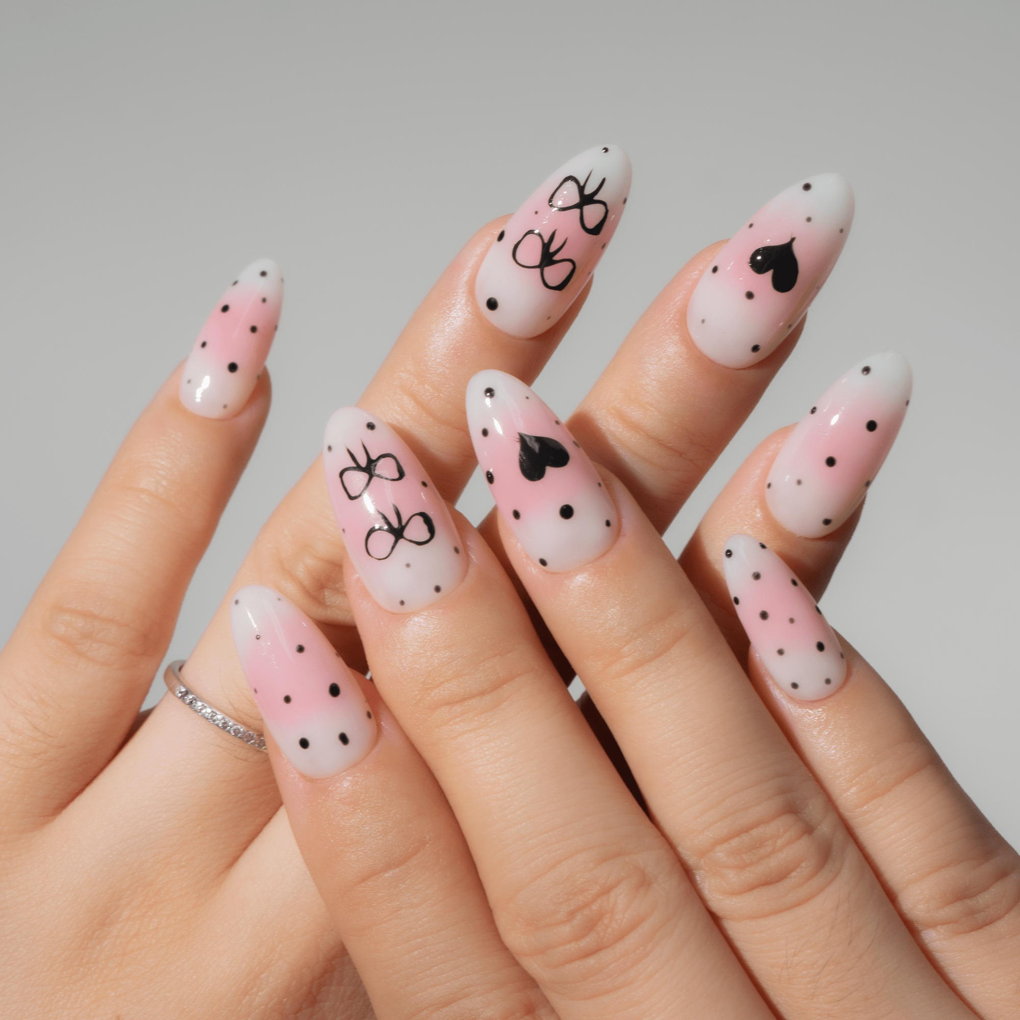 Bow Heart almond press-on nails – design close-up by Handora