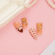 Brownie Kitty press-on nails worn on hand – almond shape by Handora