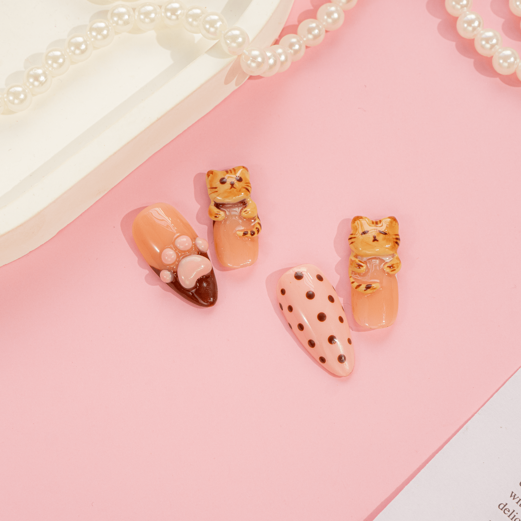Brownie Kitty press-on nails worn on hand – almond shape by Handora