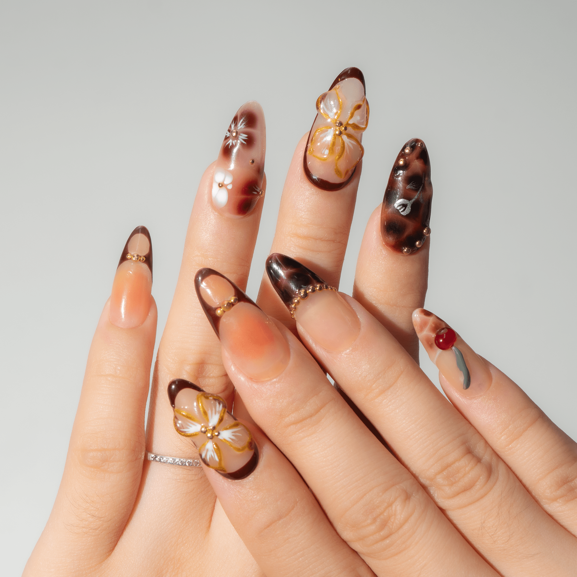 Cherry Bloom press-on nails worn on hand – almond shape by Handora