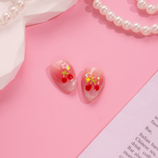 Cherry Starlet press-on nails worn on hand – almond shape by Handora