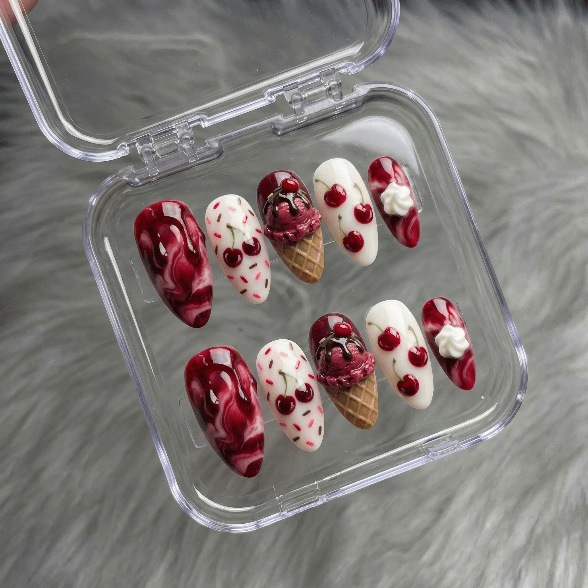 Cherry Sundae press-on nails worn on hand – almond shape by Handora