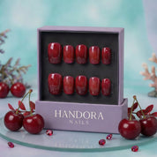 Cherry Velvet press-on nails worn on hand – almond shape by Handora