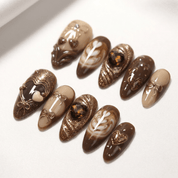 Cocoa Kisses press-on nails worn on hand – almond shape by Handora