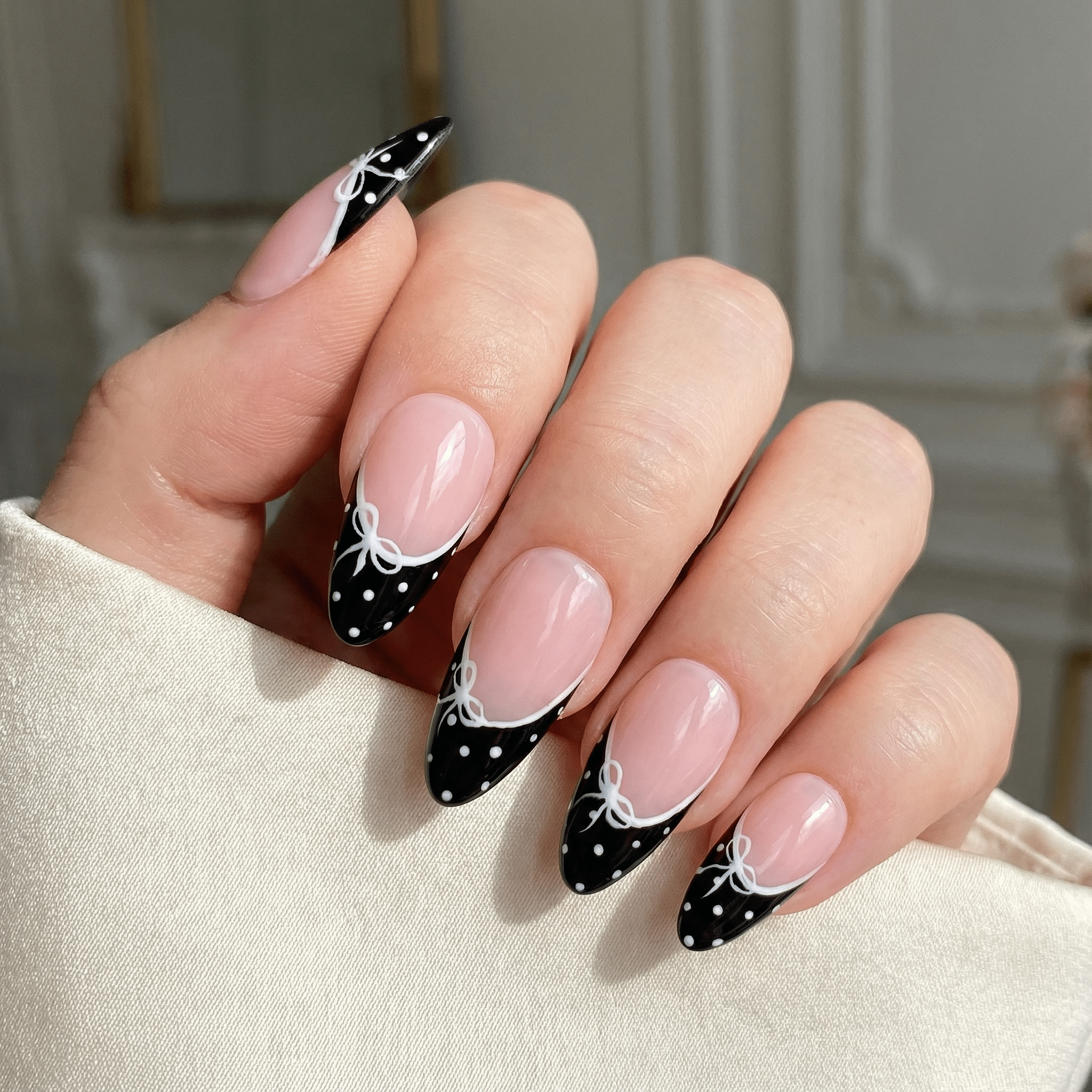 Coquette Bow press-on nails worn on hand – almond shape by Handora