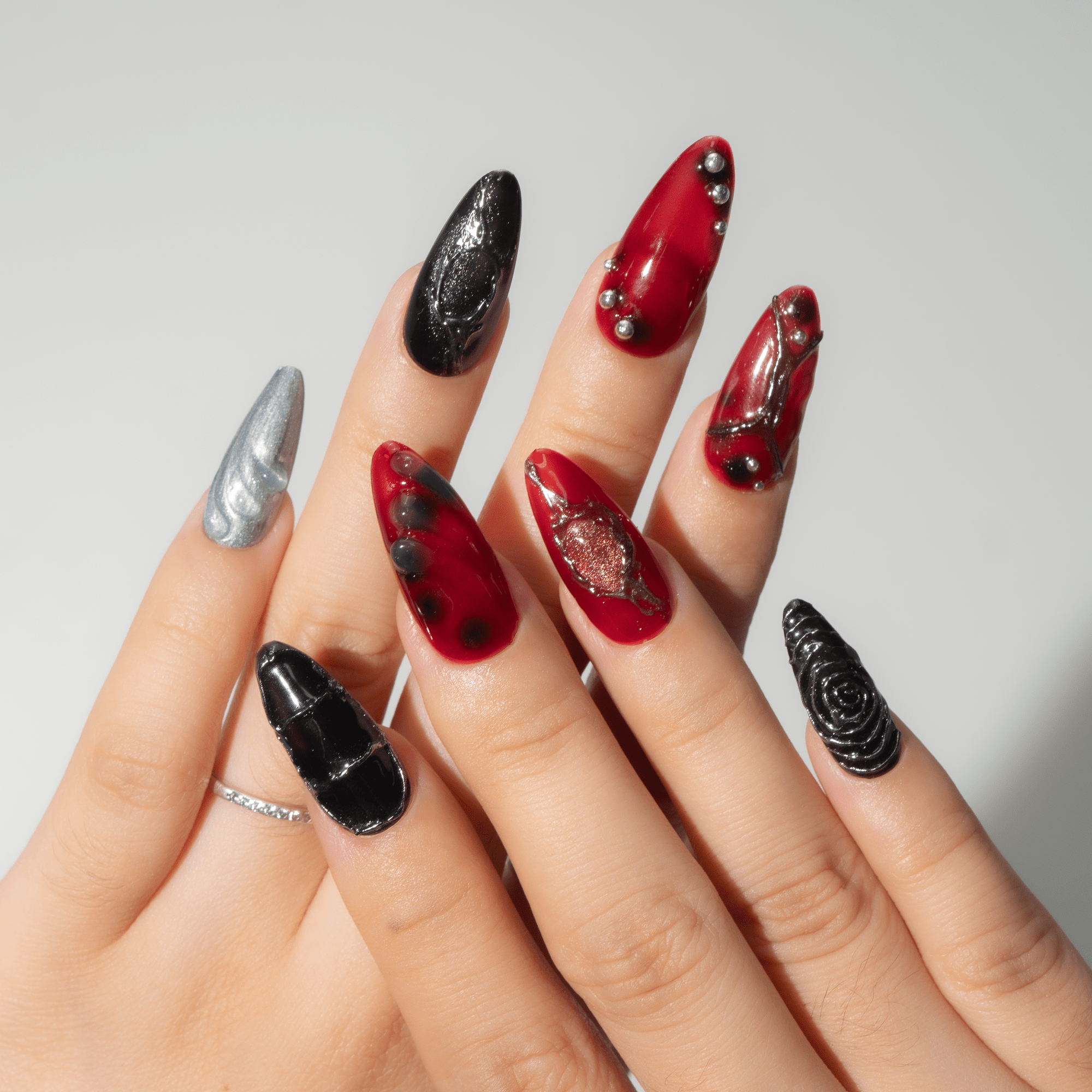 Dark Ember press-on nails worn on hand – almond shape by Handora