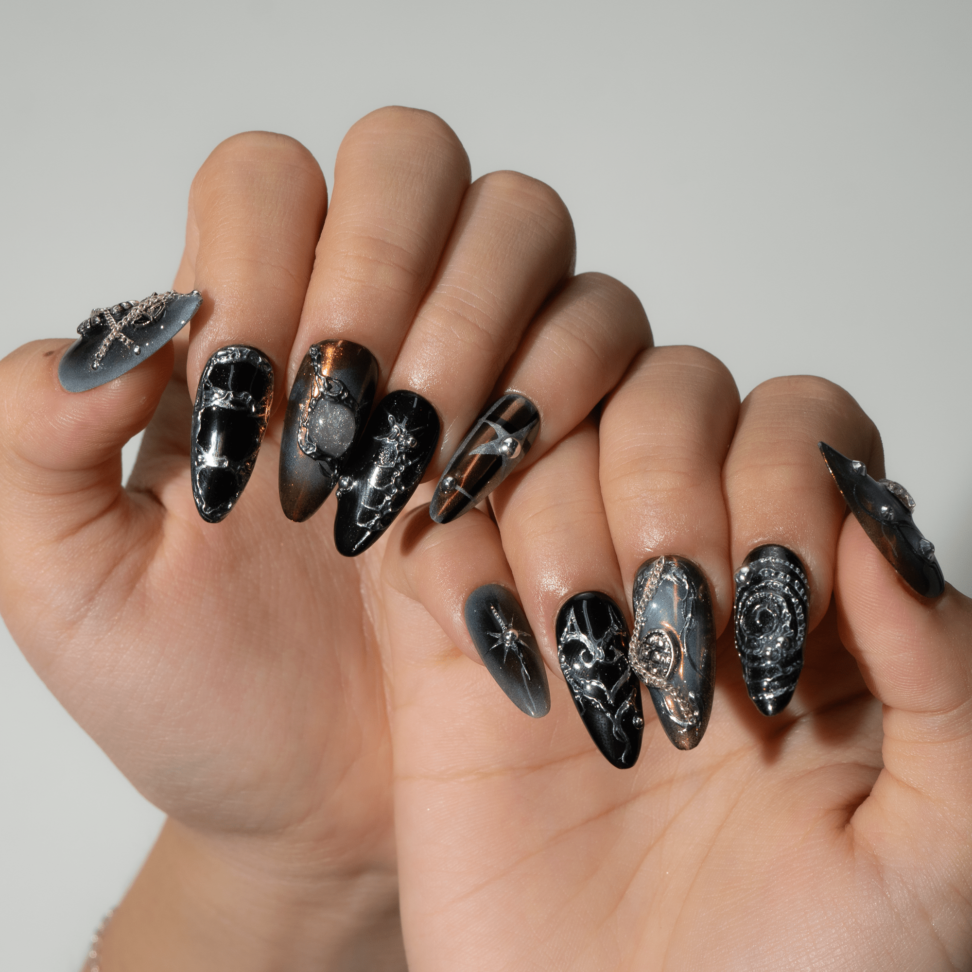 Dark Enchant press-on nails worn on hand – almond shape by Handora