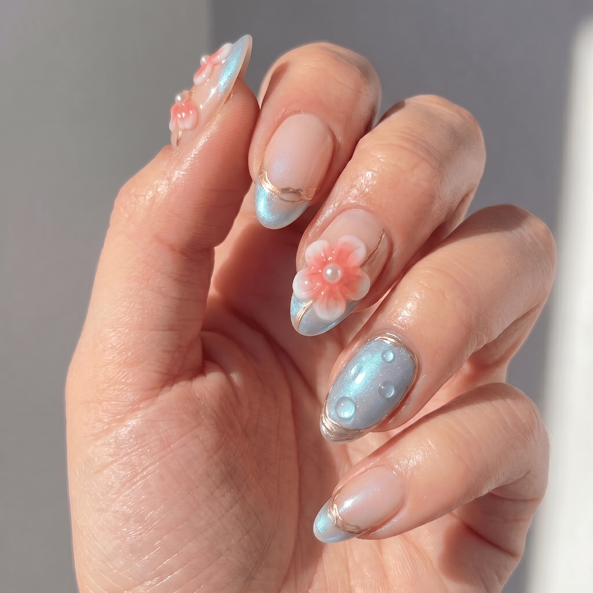 Floral Dewdrop press-on nails worn on hand – almond shape by Handora