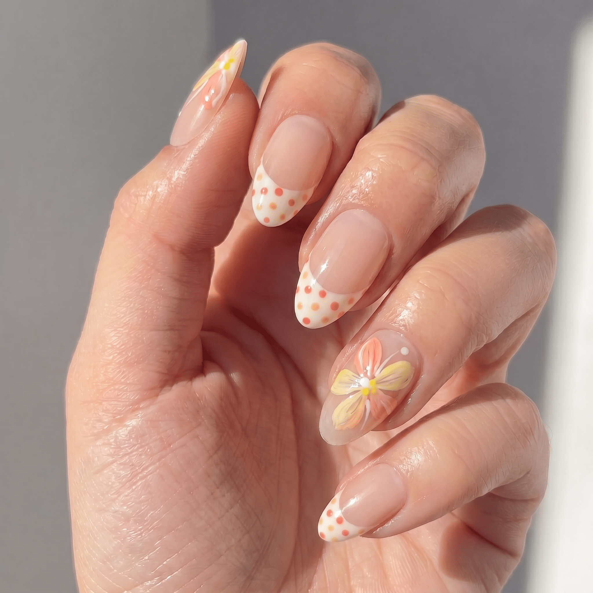 Floral Dots press-on nails worn on hand – almond shape by Handora