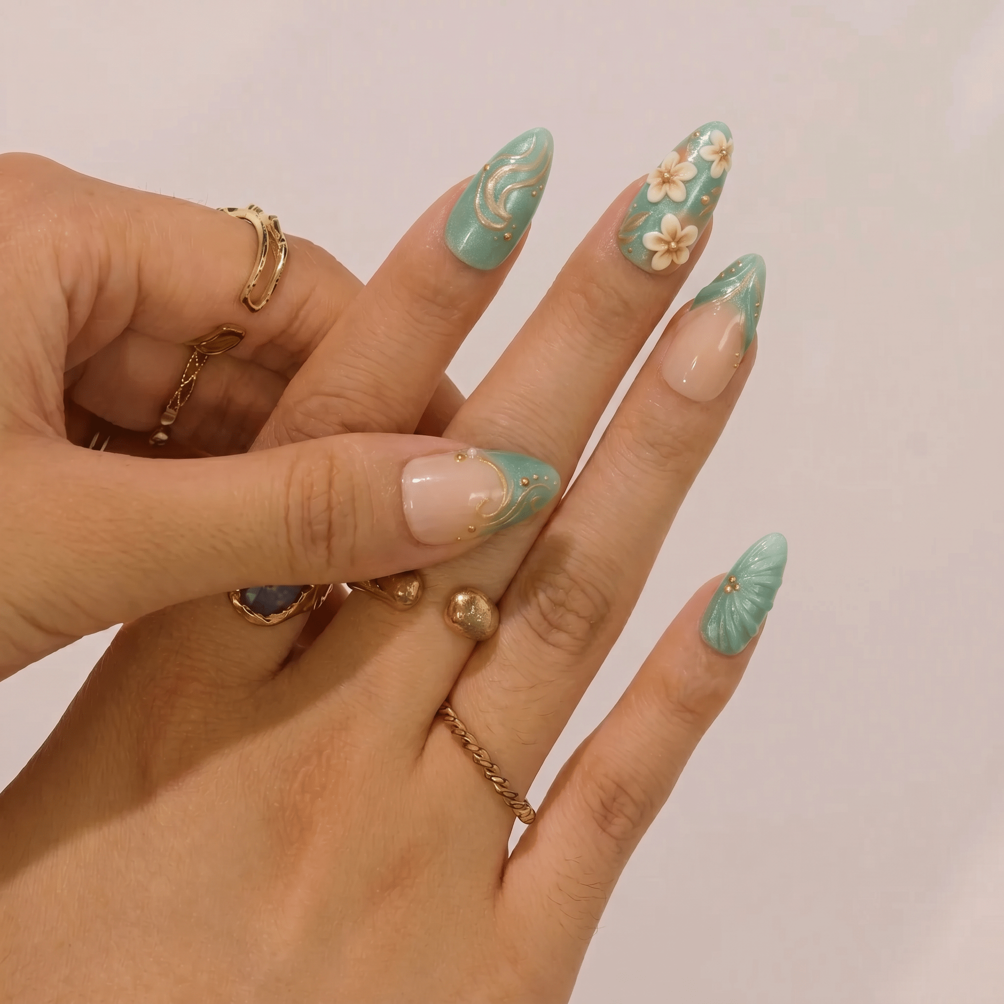 Floral Seafoam press-on nails worn on hand – almond shape by Handora