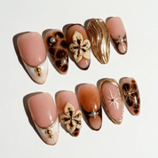 Floral Tortoise press-on nails worn on hand – almond shape by Handora