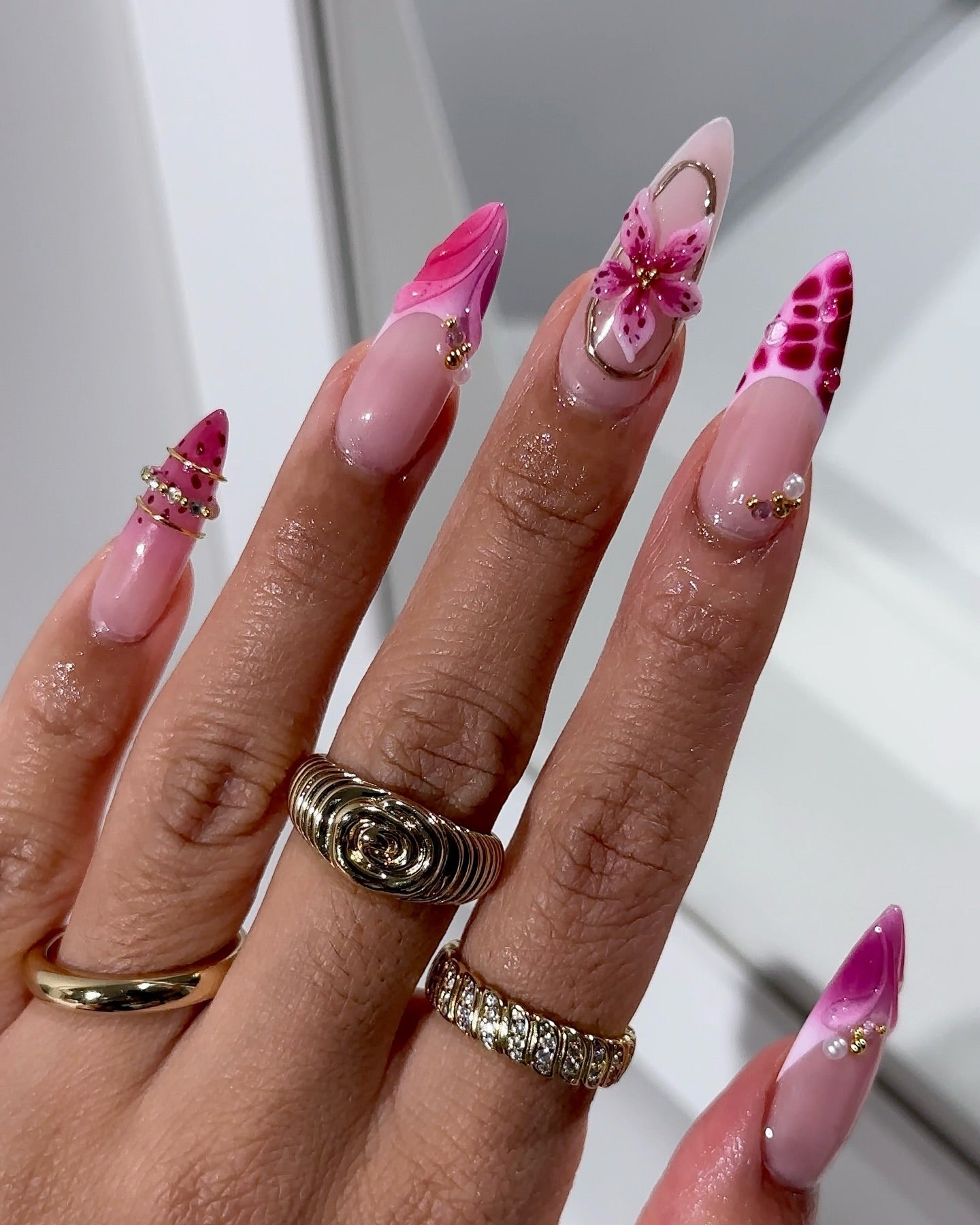 Fuchsia Flora press-on nails worn on hand – almond shape by Handora