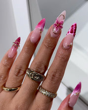 Fuchsia Flora press-on nails worn on hand – almond shape by Handora