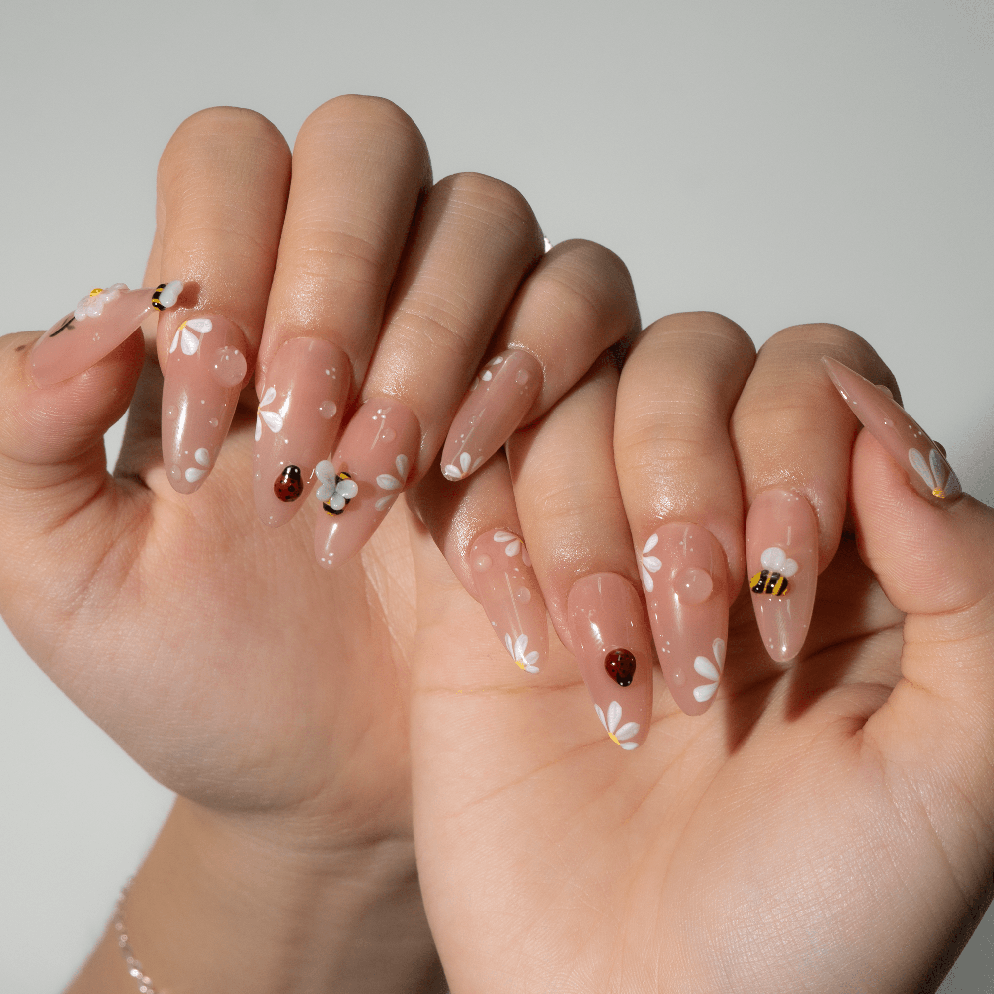 Garden Insects press-on nails worn on hand – almond shape by Handora