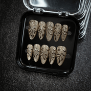 Gilded Foliage press-on nails worn on hand – almond shape by Handora