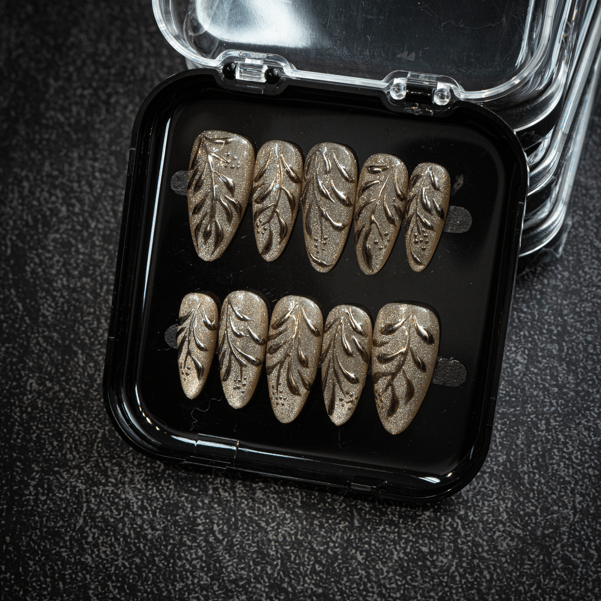 Gilded Foliage press-on nails worn on hand – almond shape by Handora