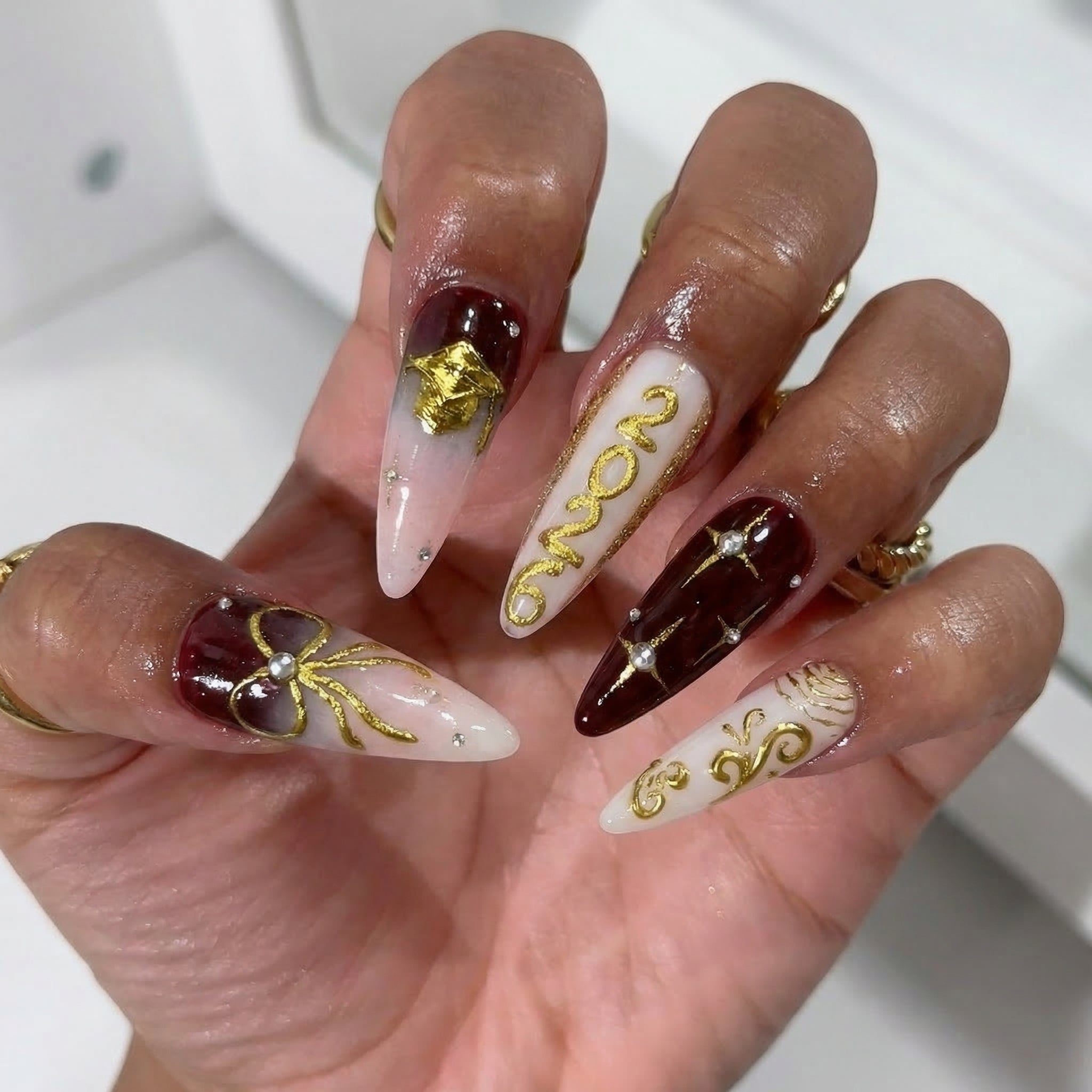 Gilded Graduate press-on nails worn on hand – almond shape by Handora