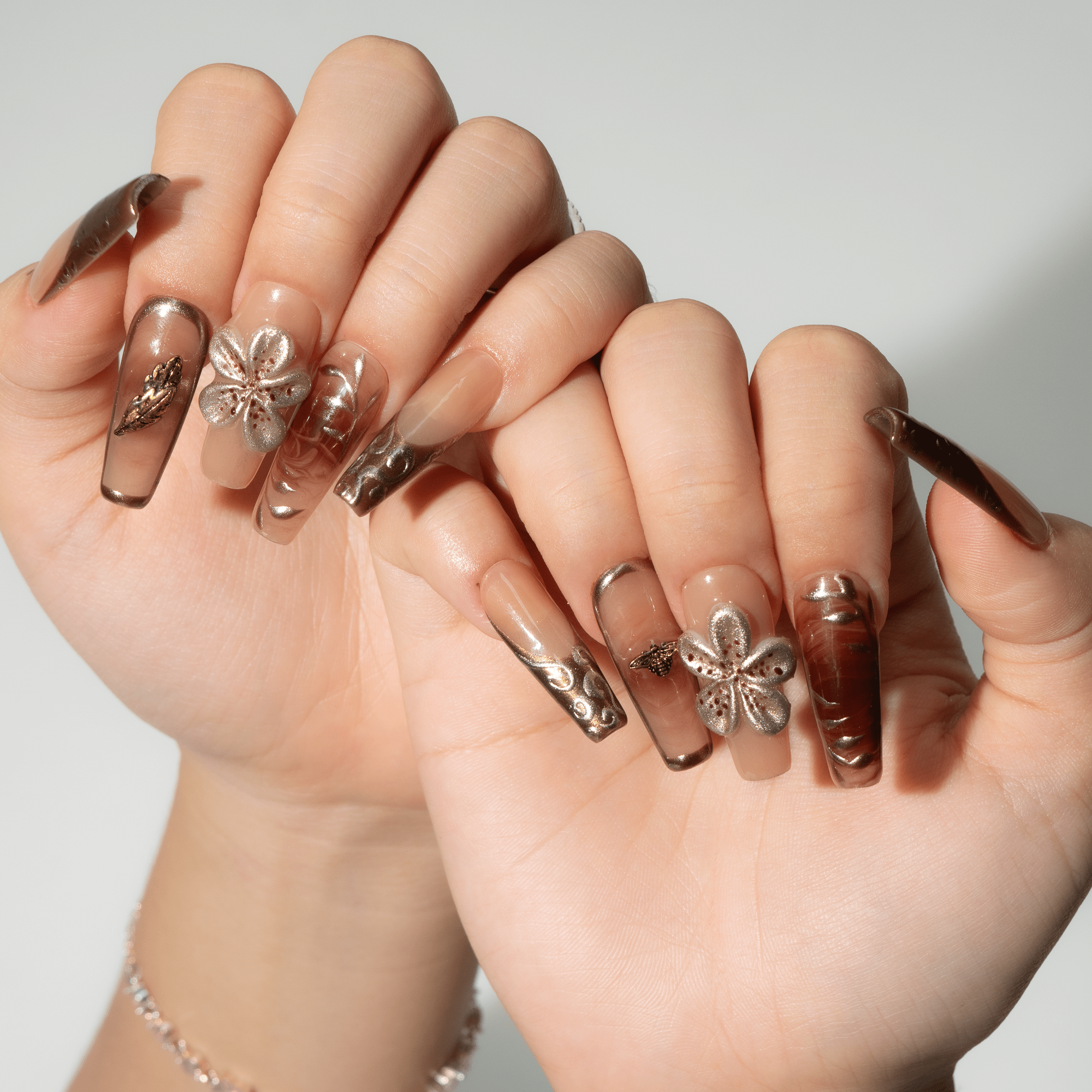 Golden Bloom press-on nails worn on hand – almond shape by Handora
