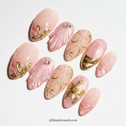 Golden Floral press-on nails worn on hand – almond shape by Handora