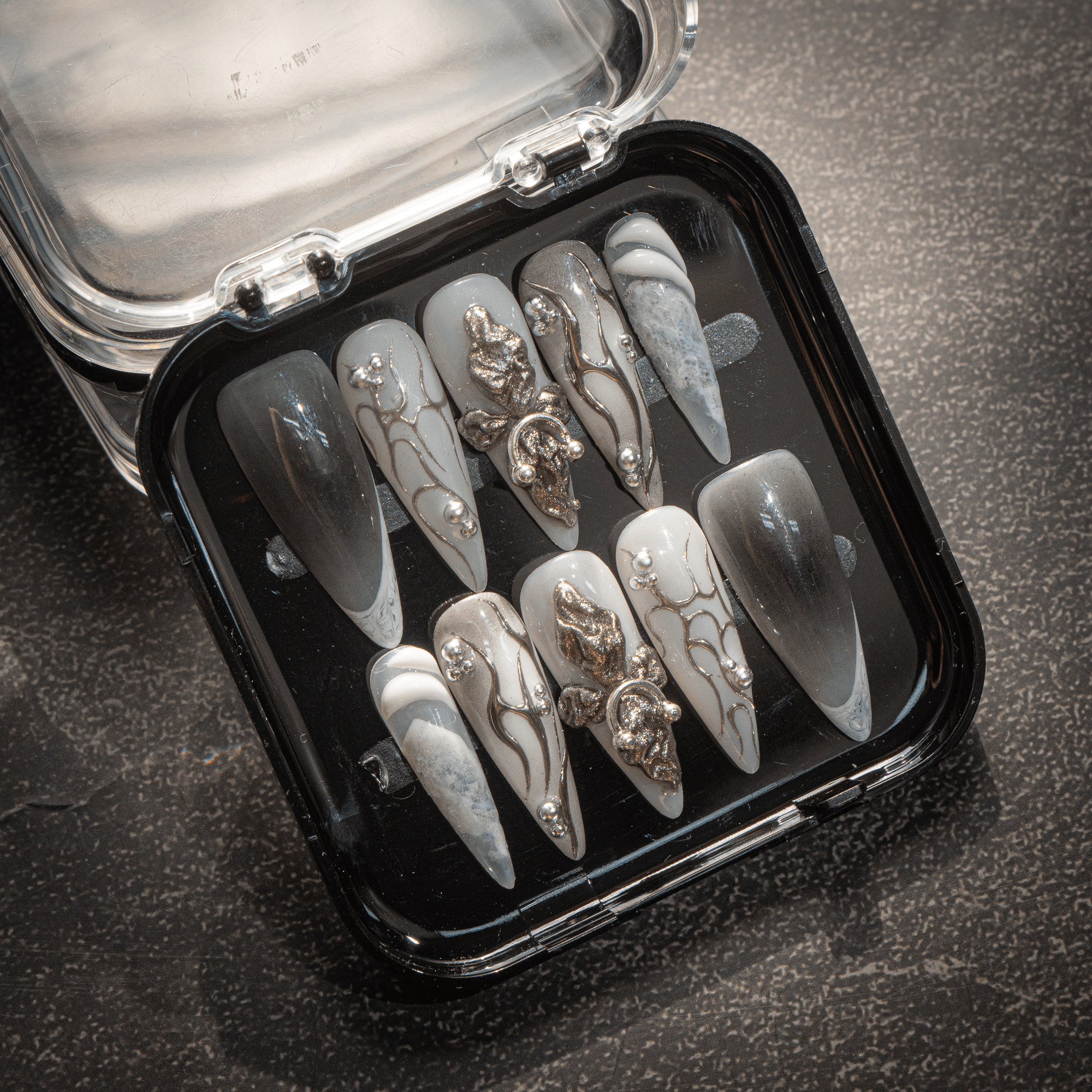 Gothic Chrome press-on nails worn on hand – almond shape by Handora