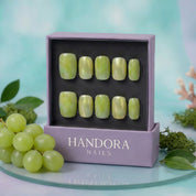 Green Grape press-on nails worn on hand – almond shape by Handora