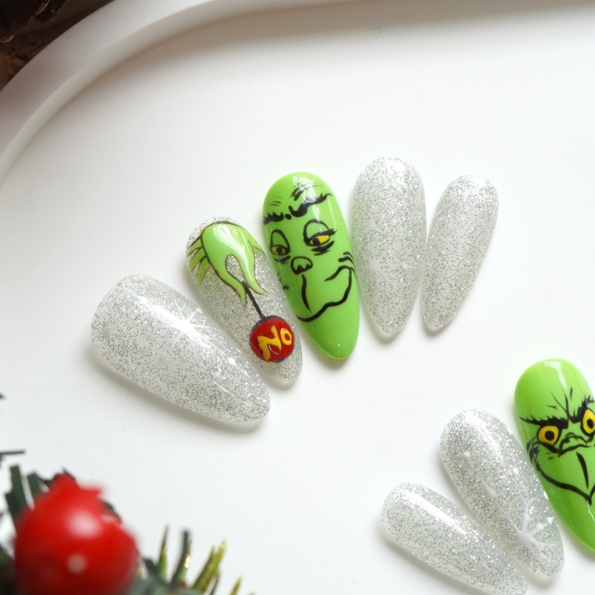 Green Sparkle press-on nails worn on hand – almond shape by Handora