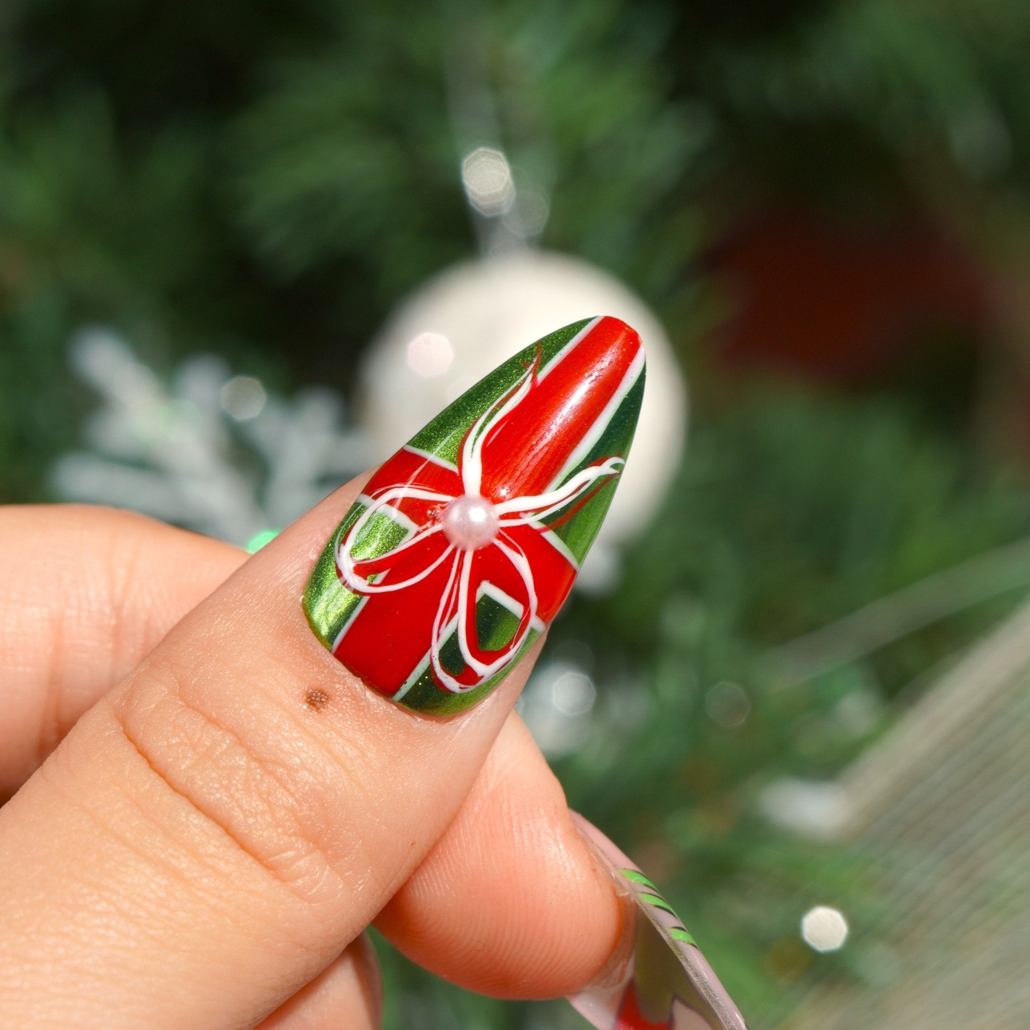 Green Xmas almond press-on nails – design close-up by Handora