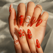 Holiday Bloom press-on nails worn on hand – almond shape by Handora
