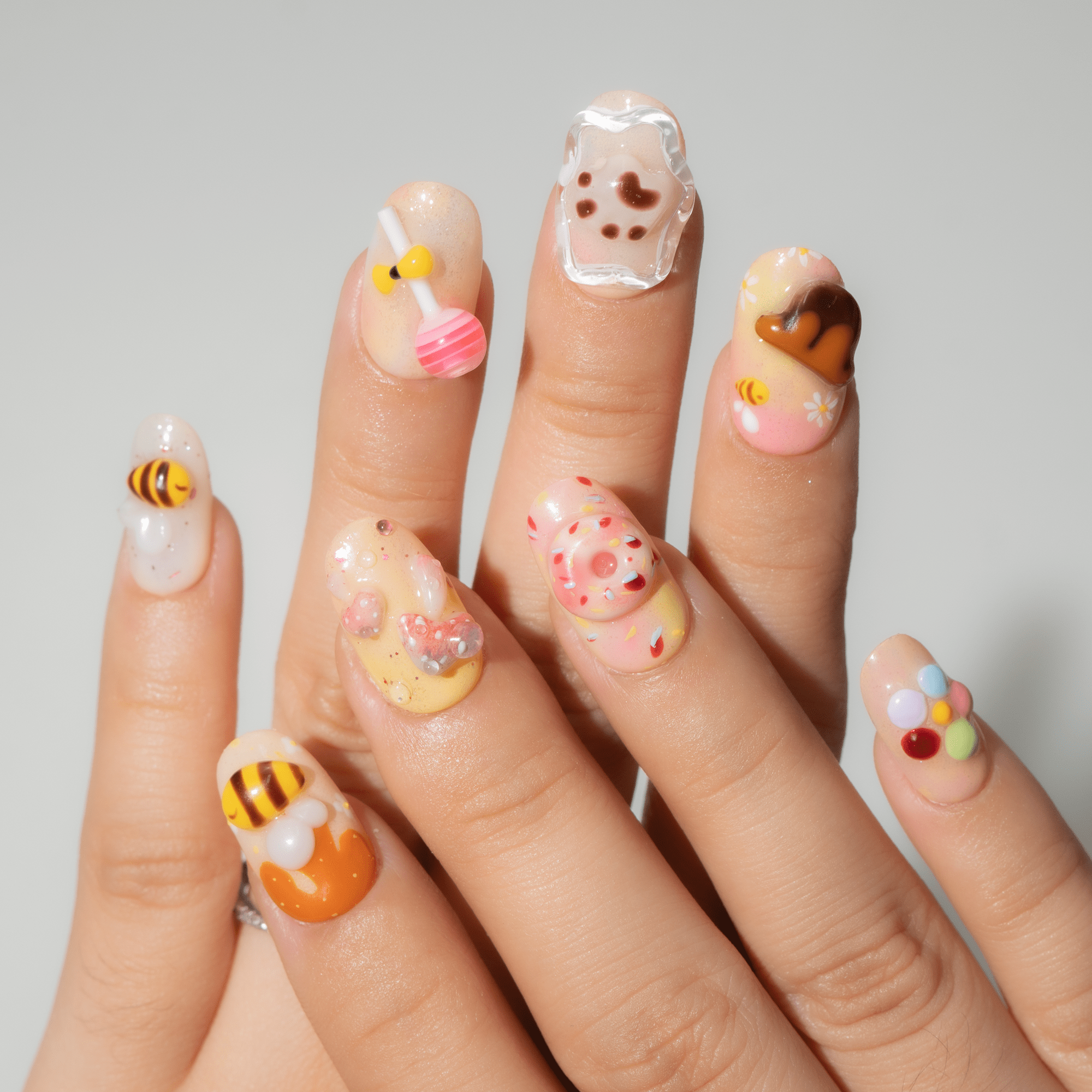 Honey Bear press-on nails worn on hand – almond shape by Handora