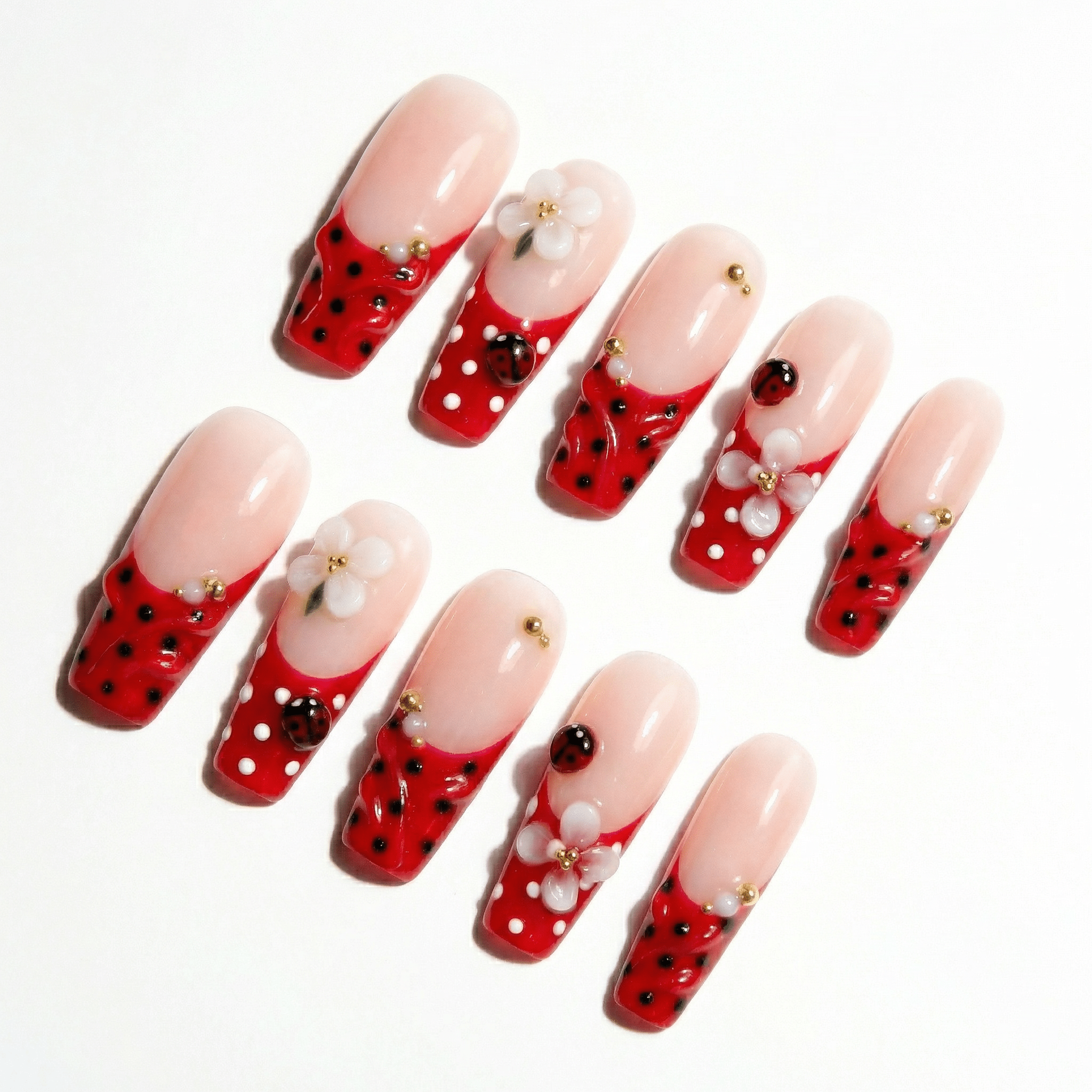 Ladybug Blossom press-on nails worn on hand – coffin shape by Handora