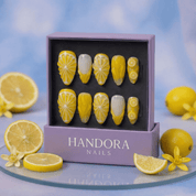 Lemon Glow press-on nails worn on hand – almond shape by Handora
