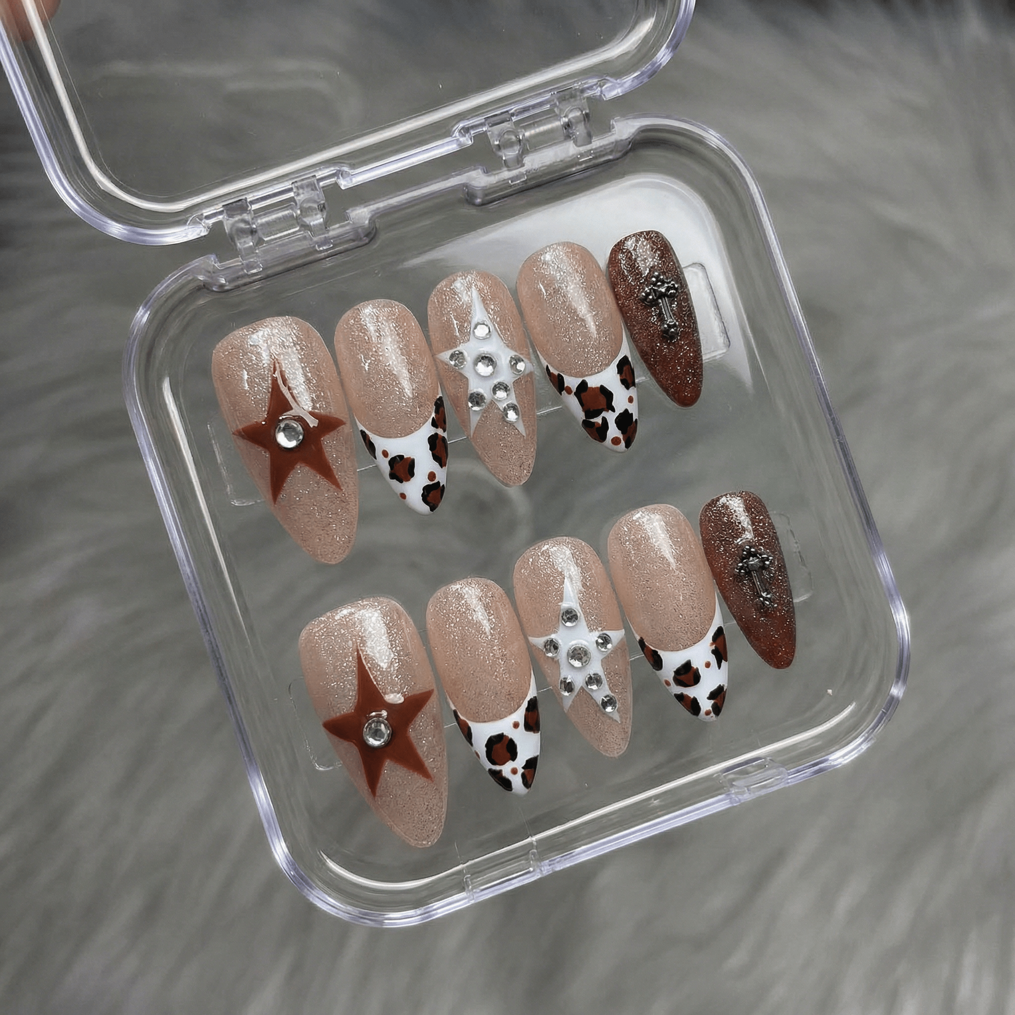 Leopard Stars press-on nails worn on hand – almond shape by Handora
