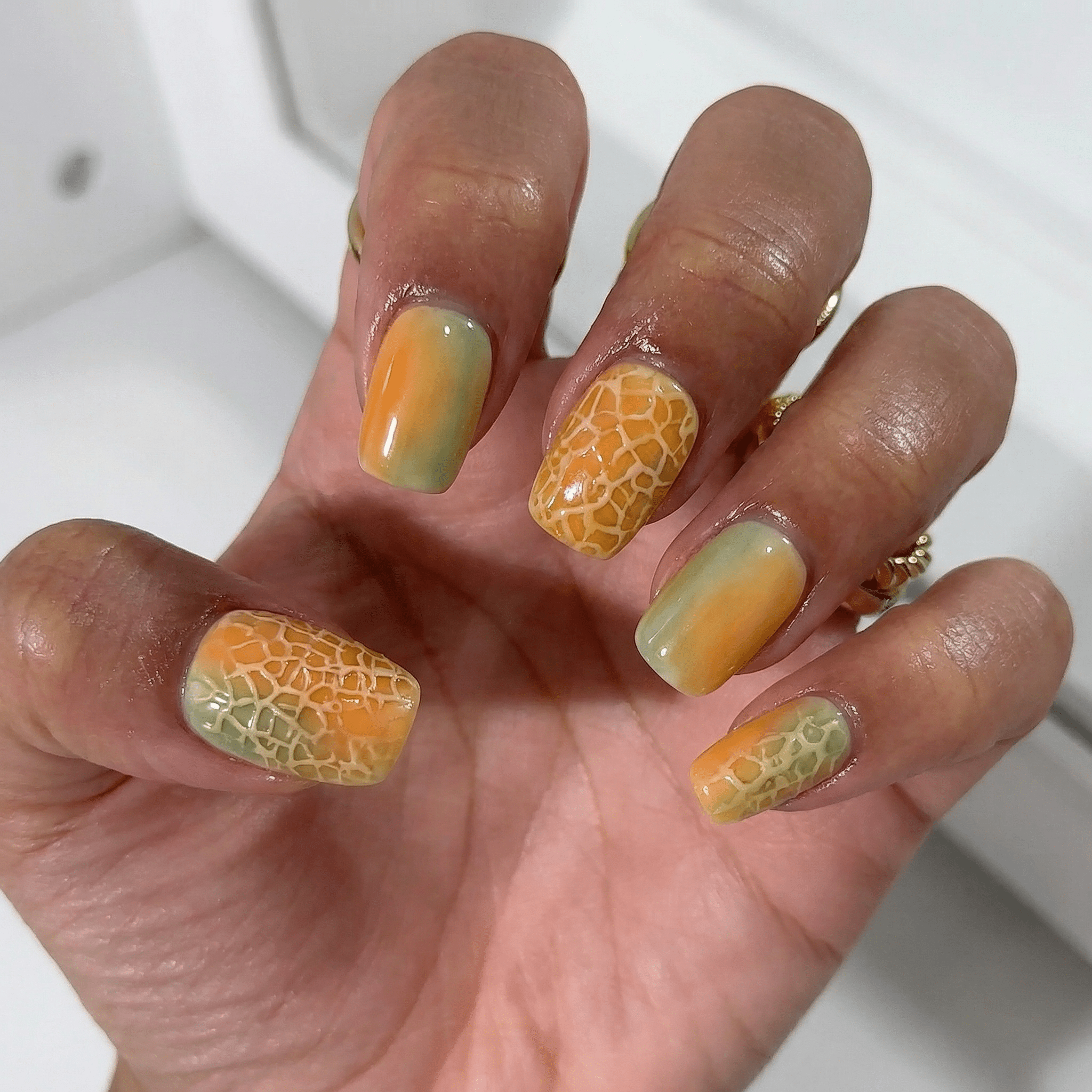 Melon Glow press-on nails worn on hand – almond shape by Handora