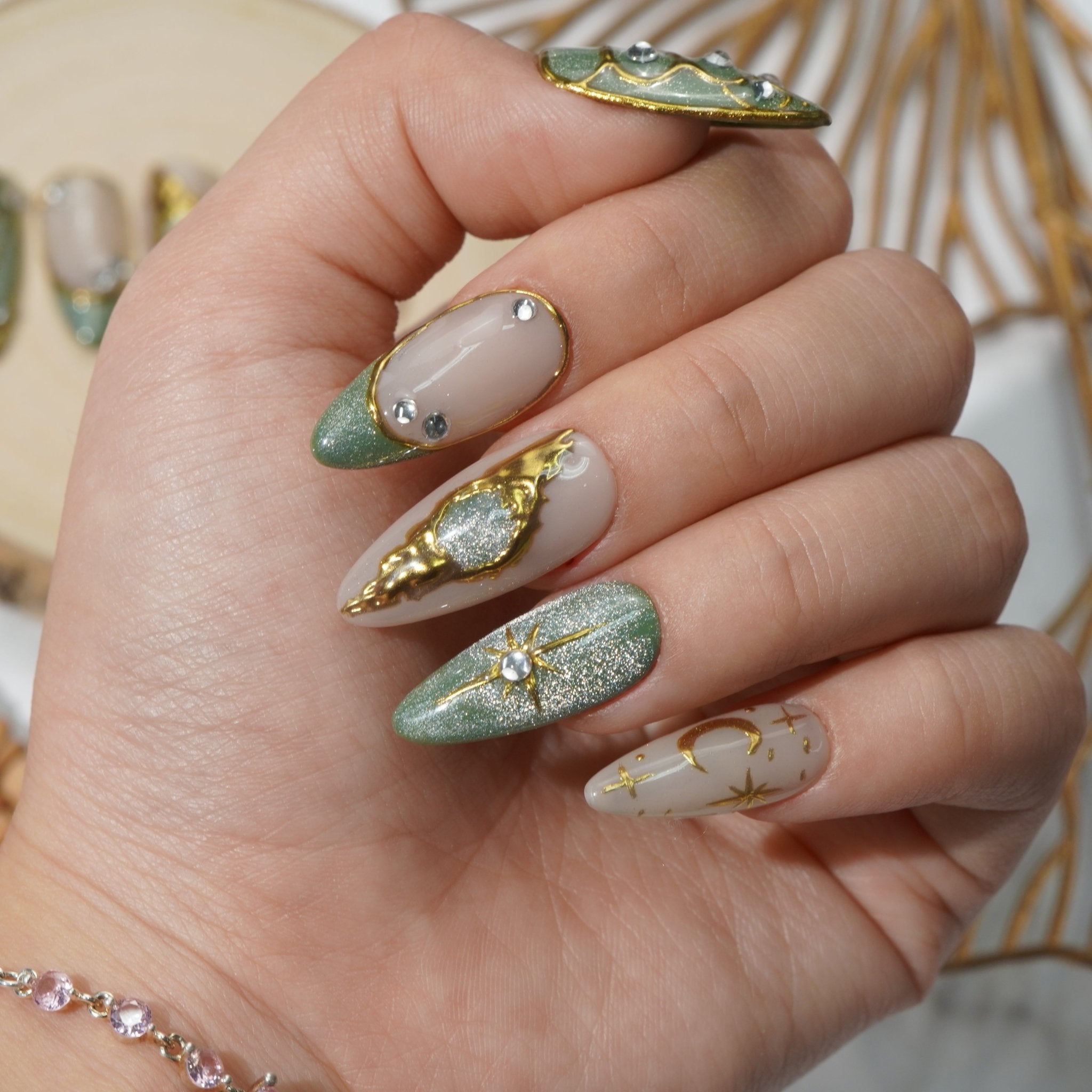 Mystic Green press-on nails worn on hand – almond shape by Handora