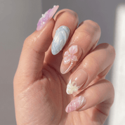 Ocean Fantasy press-on nails worn on hand – almond shape by Handora