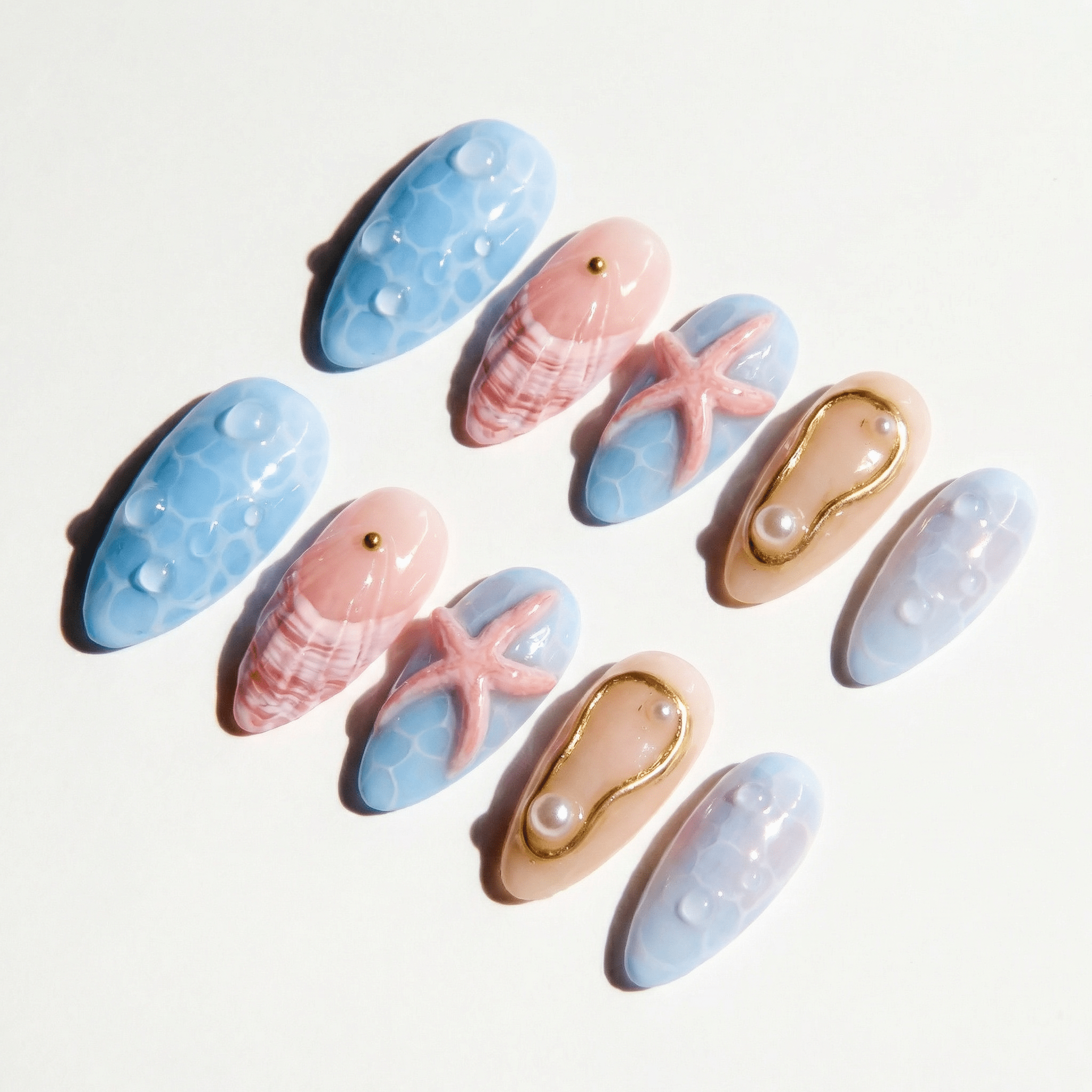 Ocean Siren press-on nails worn on hand – almond shape by Handora