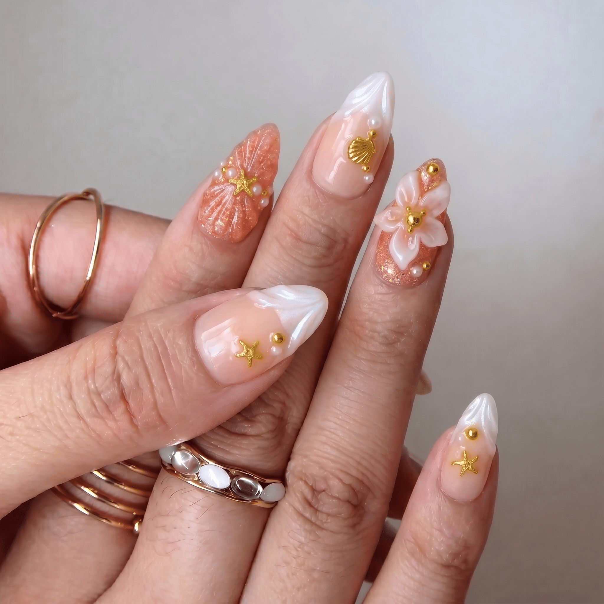 Oceanic Glamour press-on nails worn on hand – almond shape by Handora