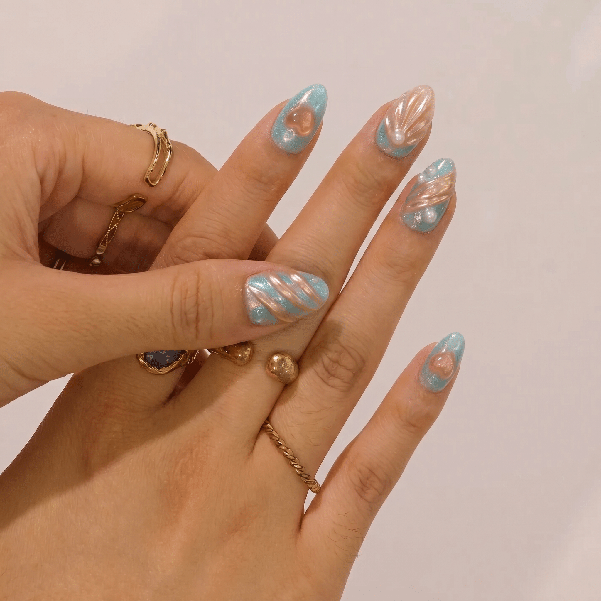 Oceanic Heart press-on nails worn on hand – almond shape by Handora