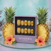 Pineapple Slice press-on nails worn on hand – almond shape by Handora