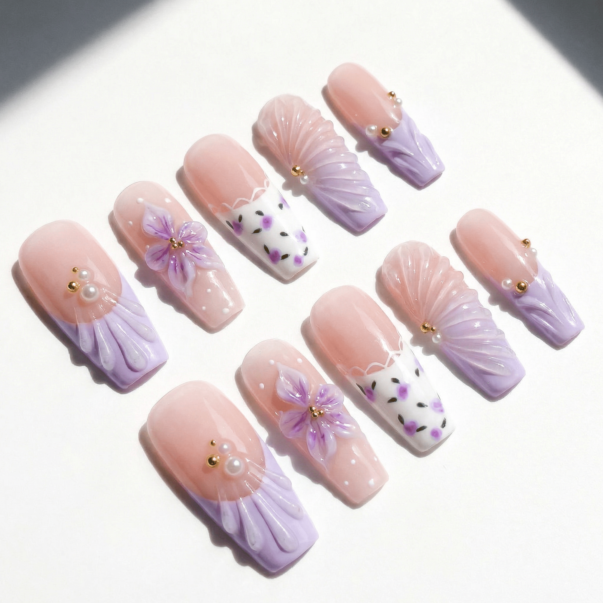 Purple Bloom press-on nails worn on hand – almond shape by Handora